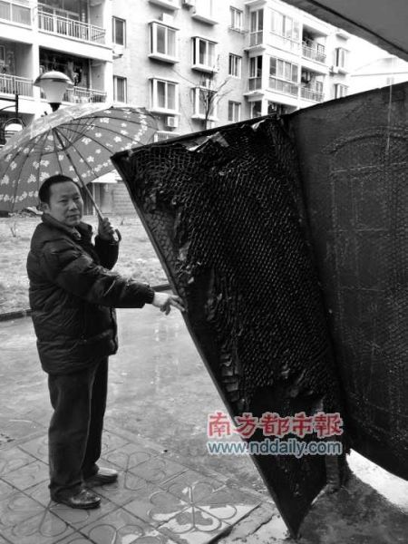 一名灾民拉开安置房的单元门,两块铁皮里面夹着的是纸板。南都记者王世宇摄 一名灾民拉开安置房的单元门,两块铁皮里面夹着的是纸板。南都记者王世宇摄