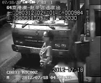 4∶19∶09:女收费员拦在货车前,阻挡该车通过。