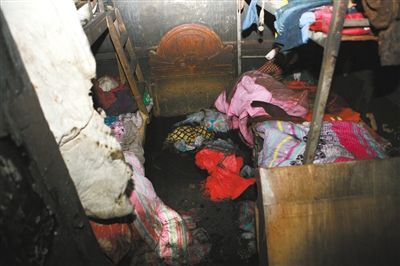 事故现场衣服棉被散落一地。火灾造成7人丧生,其中6名儿童,1名成人,并有1名儿童受伤。王中举 摄