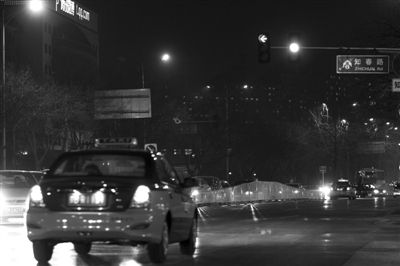 昨日,知春路,一辆出租车在黄灯中驶过路口。新京报记者